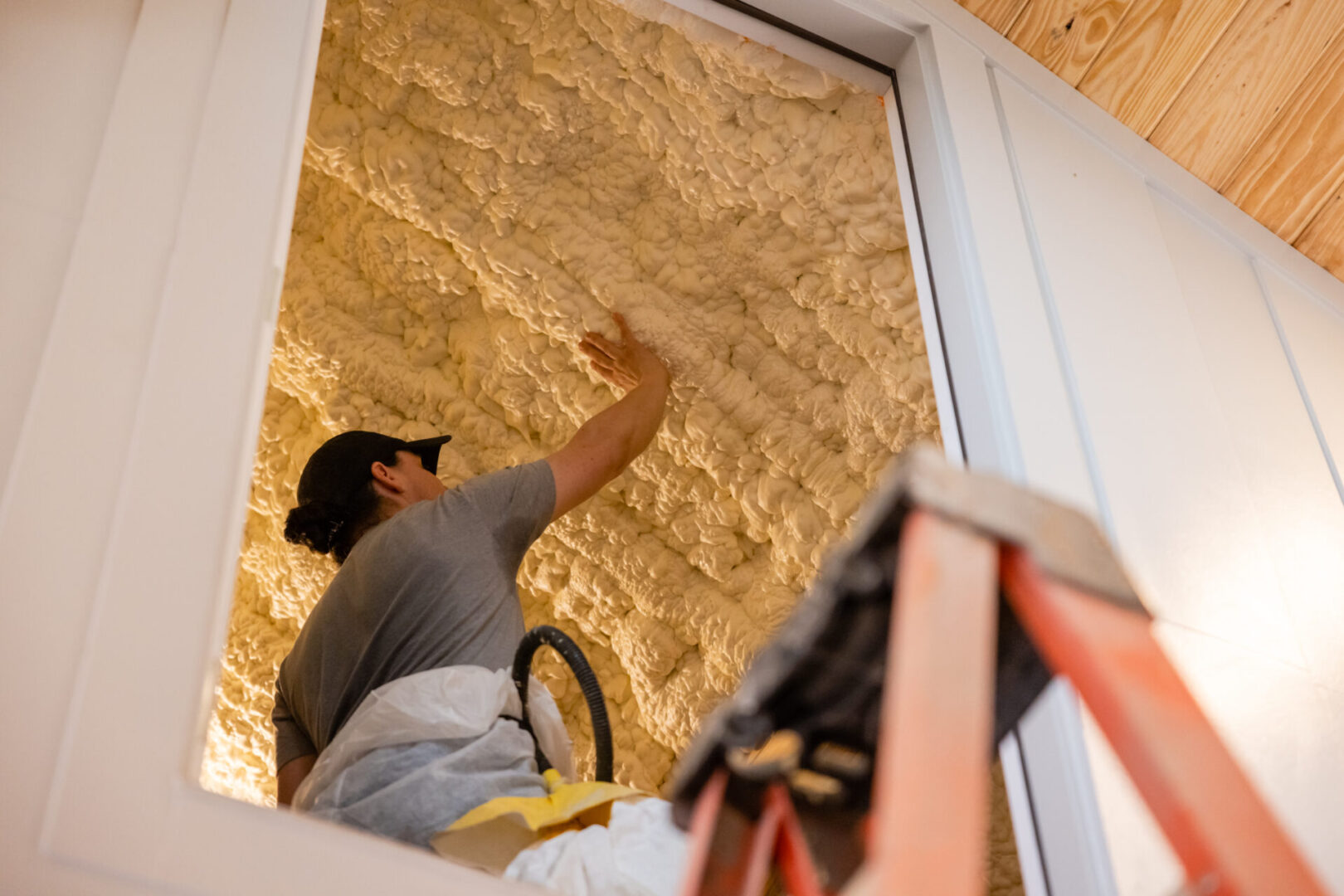 A man is working on the wall of his home.